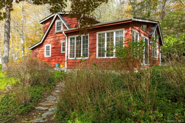 a front view of a house with a yard and trees