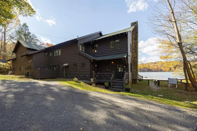 a view of a patio with lawn chairs floor to ceiling window next to a yard