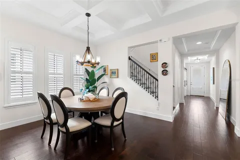 a dining room with furniture a chandelier and wooden floor
