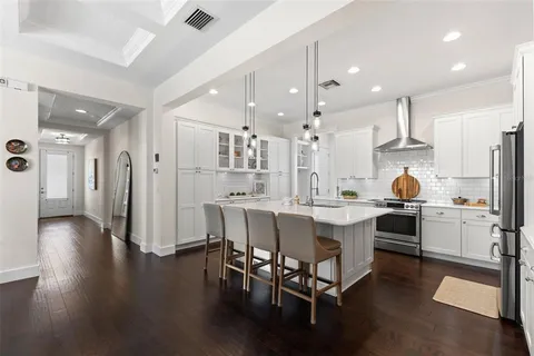 a kitchen with stainless steel appliances kitchen island granite countertop a table chairs and a sink