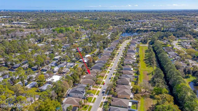 an aerial view of residential houses with outdoor space and trees