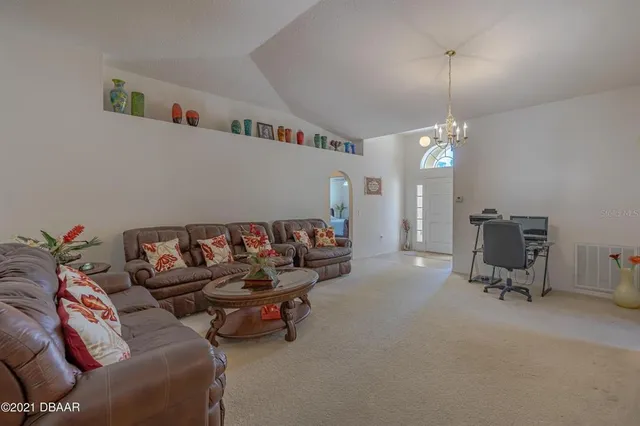 a living room with furniture and a chandelier
