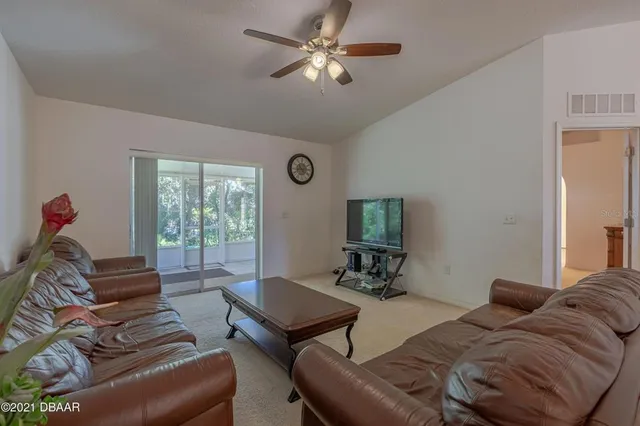 a living room with furniture ceiling fan and a window