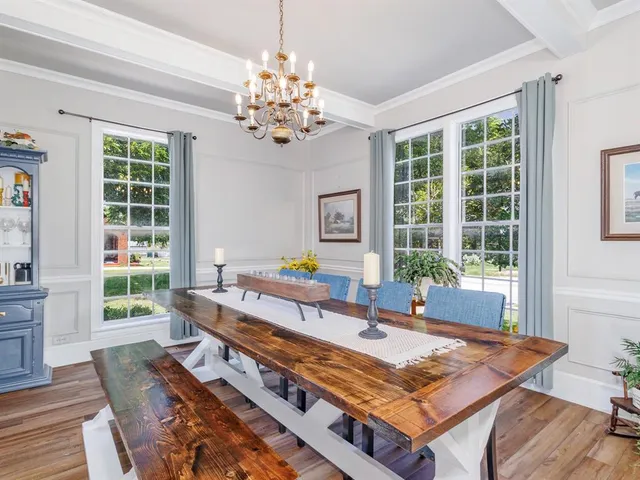 a living room with furniture a dining table and a chandelier