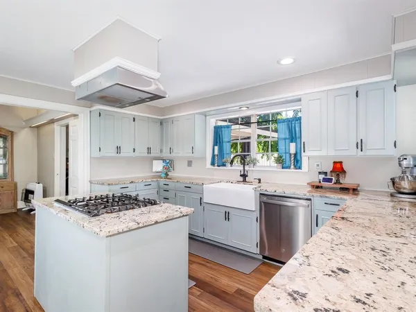 a kitchen with a stove a sink a refrigerator and cabinets
