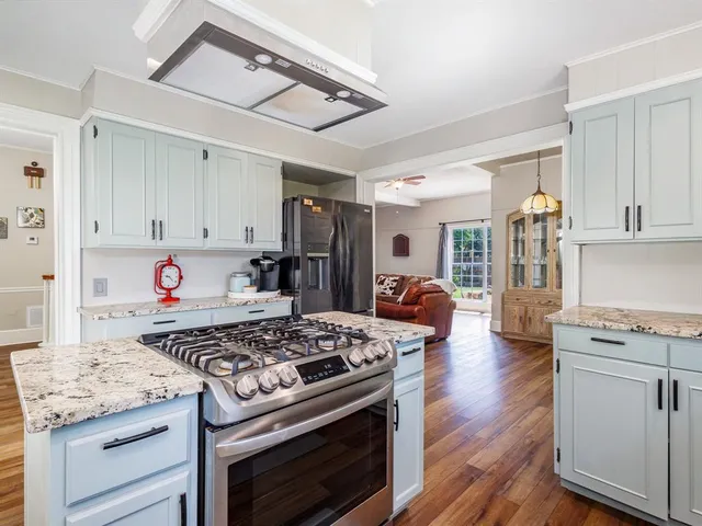 a kitchen with stainless steel appliances granite countertop a stove and a refrigerator
