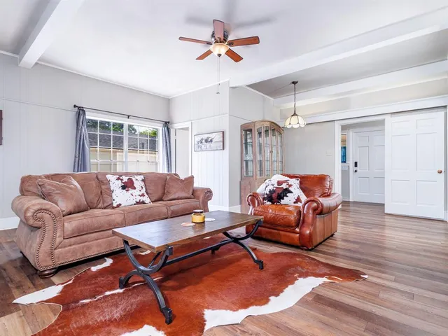 a living room with furniture a chandelier and a window