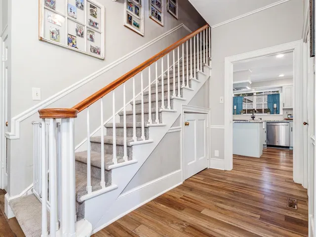 a view of staircase with white walls and wooden floor