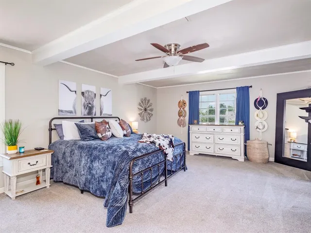 a spacious bedroom with a bed a couch and a window