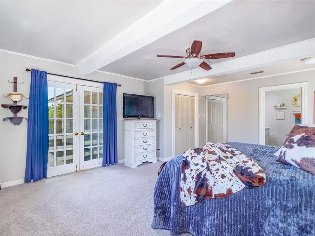 a bedroom with a bed closet and flat tv screen