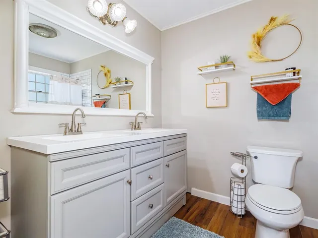 a spacious bathroom with a toilet sink and mirror