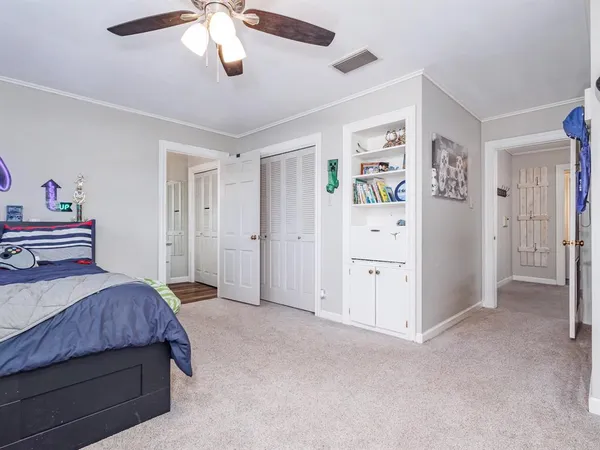 a bedroom with a large bed and ceiling fan