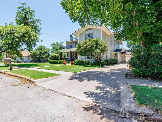 a front view of a house with a yard and trees