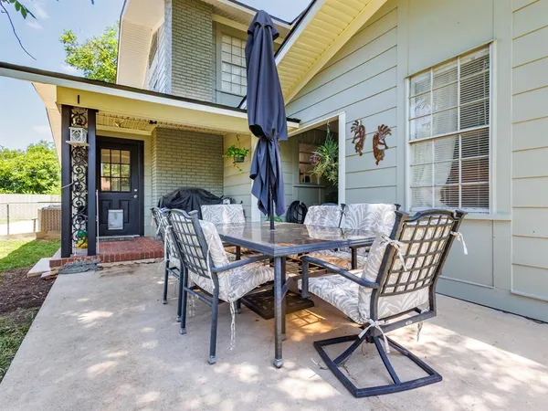 a view of a patio with table and chairs and potted plants
