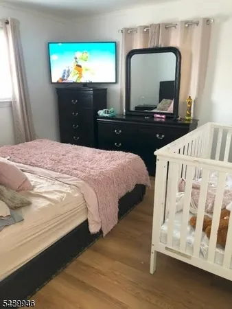 a bedroom with a bed and a flat tv screen on dresser
