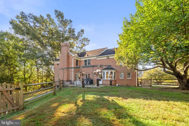 a view of a house with a big yard and large tree