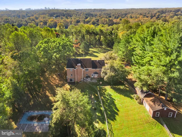 an aerial view of residential houses with outdoor space and trees