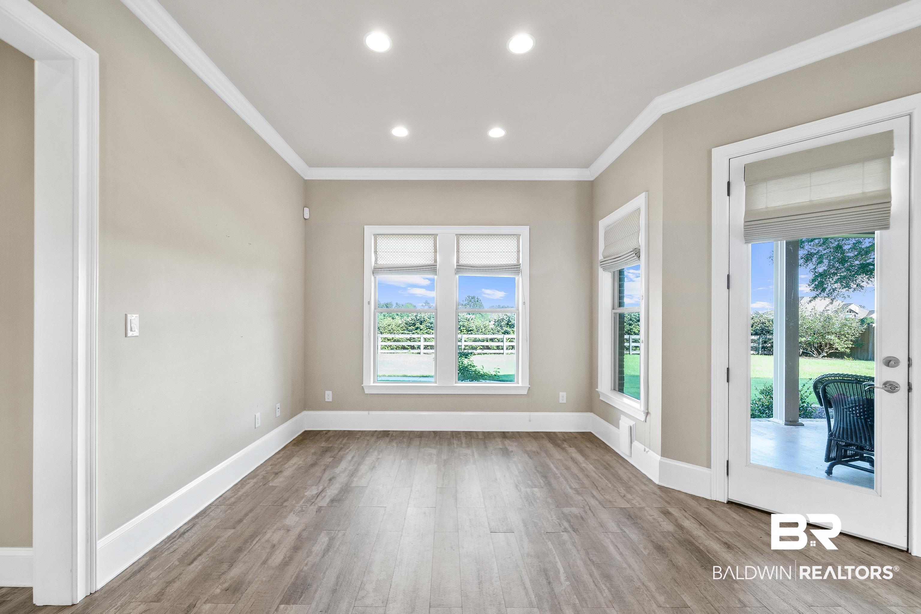 17663 Burwick Loop Fairhope, AL 36532 - Photo 18 of 41 Unfurnished room with light hardwood / wood-style flooring, ornamental molding, and french doors