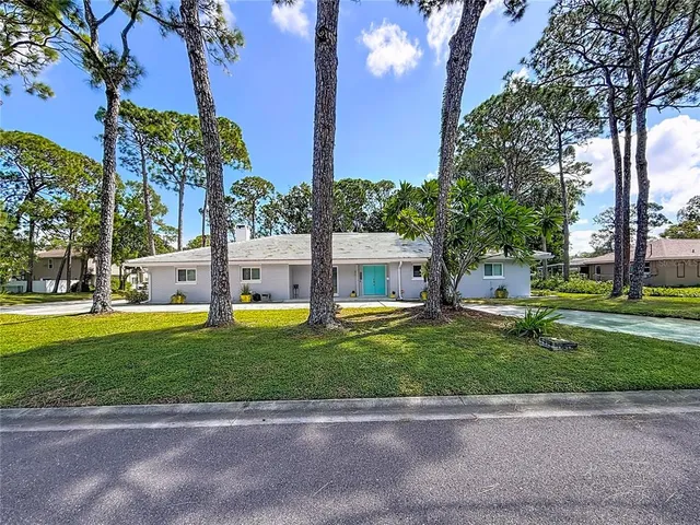 a view of a house with swimming pool next to a yard