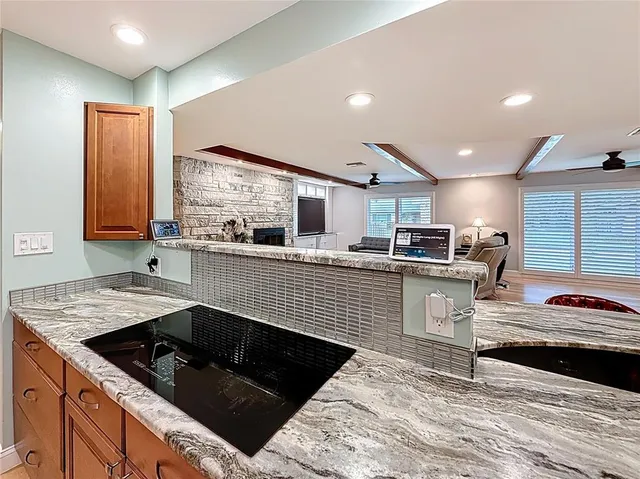 a bathroom with a granite countertop sink toilet and mirror
