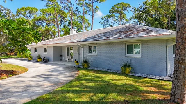 a front view of a house with a garden and potted plants