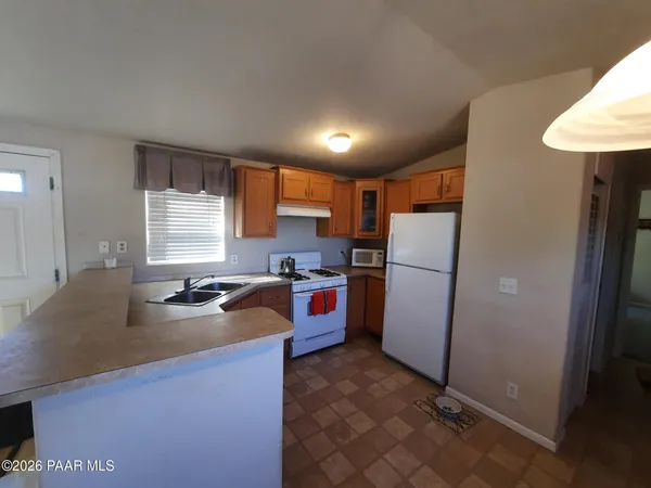 a kitchen with a refrigerator a sink a stove and cabinets