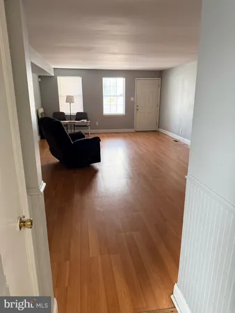 a view of a livingroom with wooden floor and furniture