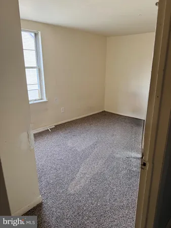 a living room with furniture and a refrigerator