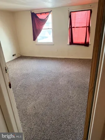 a view of an empty room with a kitchen