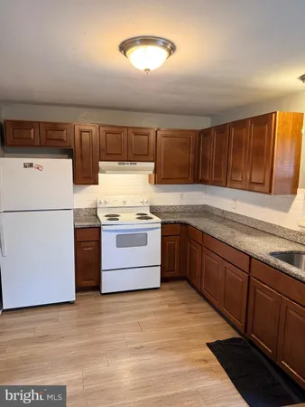a kitchen with granite countertop a sink cabinets and stainless steel appliances
