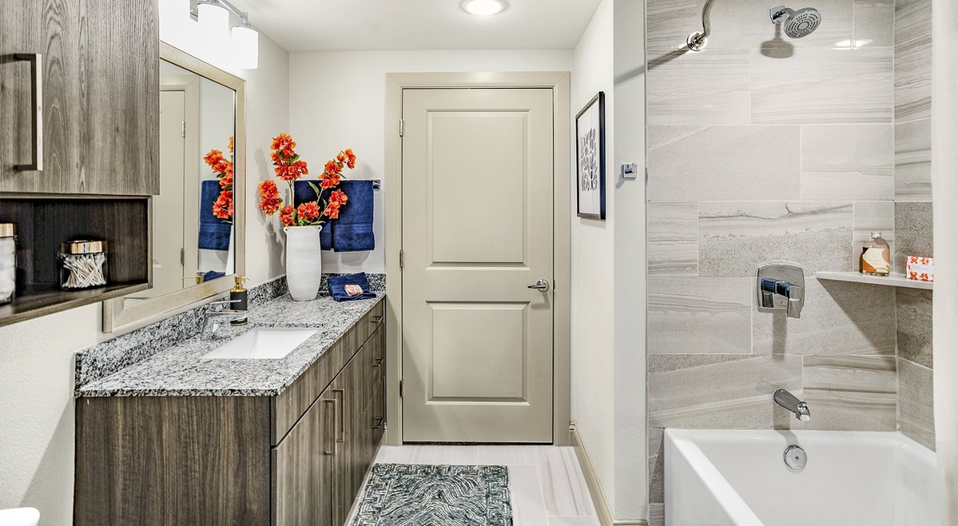 7100 Uvalde Road, Unit 9104 Houston, TX 77049 - Photo 4 of 28 a bathroom with a granite countertop tub sink and mirror