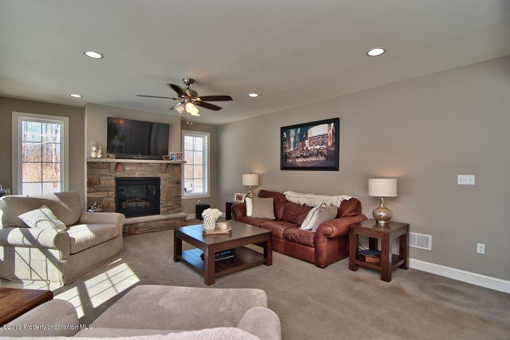 126 Highland Road Moscow, PA 18444 - Photo 40 of 77 a living room with furniture a flat screen tv and a fireplace