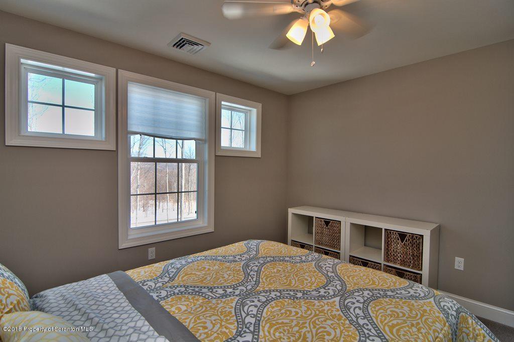 126 Highland Road Moscow, PA 18444 - Photo 50 of 77 a bedroom with a bed and a chandelier