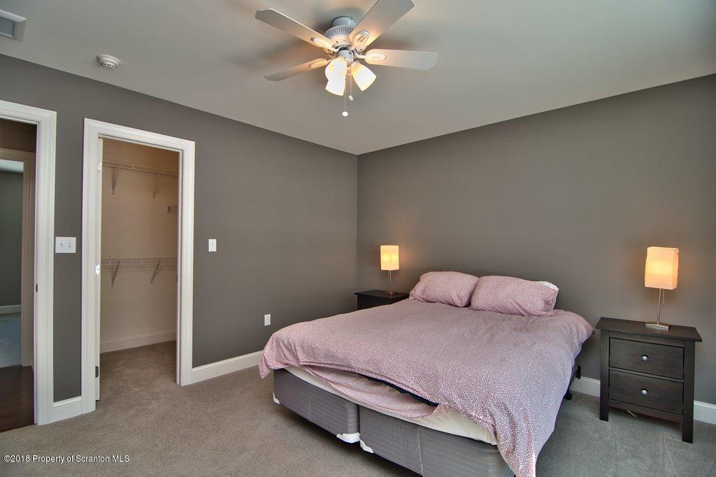 126 Highland Road Moscow, PA 18444 - Photo 55 of 77 a bedroom with a bed and a chandelier