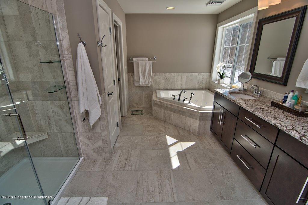 126 Highland Road Moscow, PA 18444 - Photo 71 of 77 a bathroom with a granite countertop sink a toilet a mirror and shower