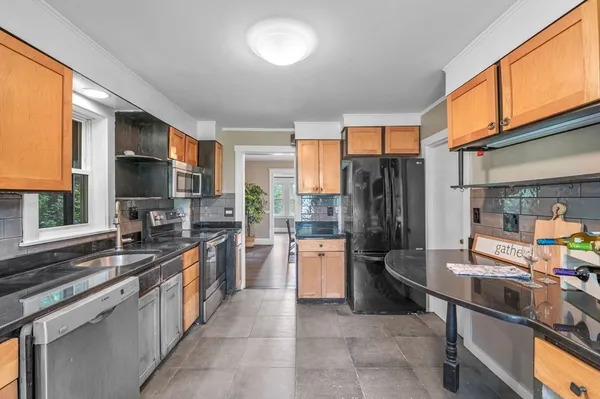 a kitchen with stainless steel appliances granite countertop a refrigerator and a stove top oven