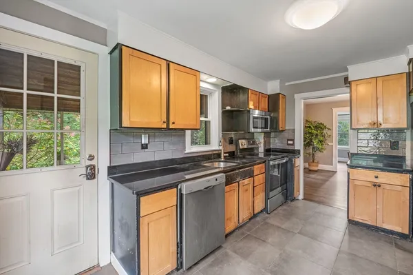 a kitchen with stainless steel appliances granite countertop a stove a sink dishwasher a refrigerator and a microwave oven