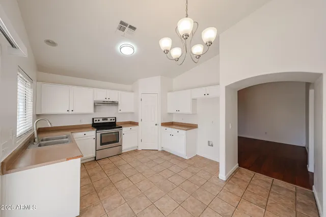 a kitchen that has a lot of cabinets and stainless steel appliances