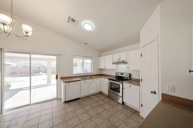 a kitchen with granite countertop white cabinets and white appliances