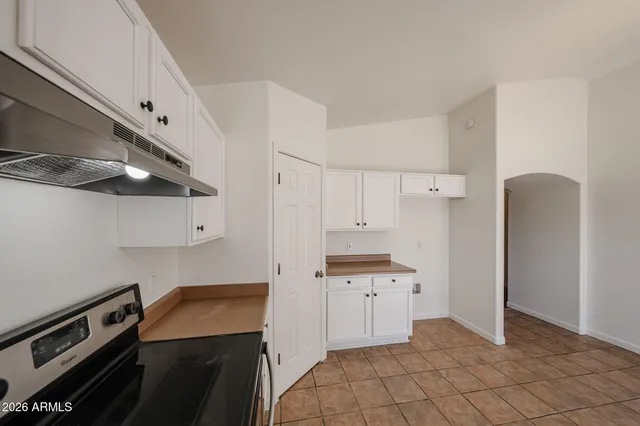 a kitchen with white cabinets and appliances