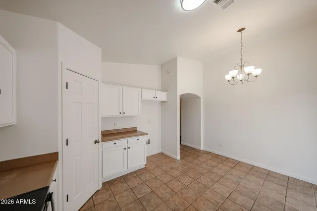 a kitchen with kitchen island white cabinets and chandelier