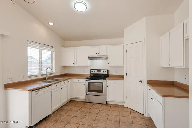 a kitchen with white cabinets stainless steel appliances and sink