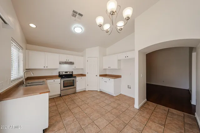 a kitchen with a stove a refrigerator and cabinets