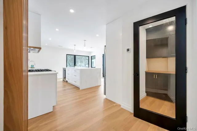 a view of a hallway with wooden floor and a living room