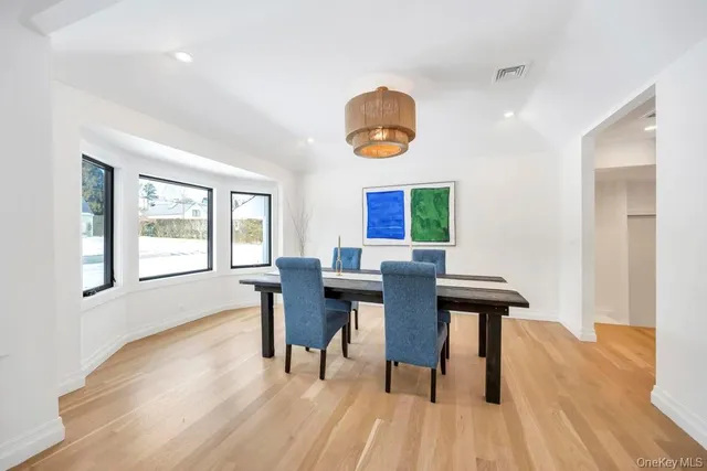 a view of a dining room with furniture a fireplace and wooden floor