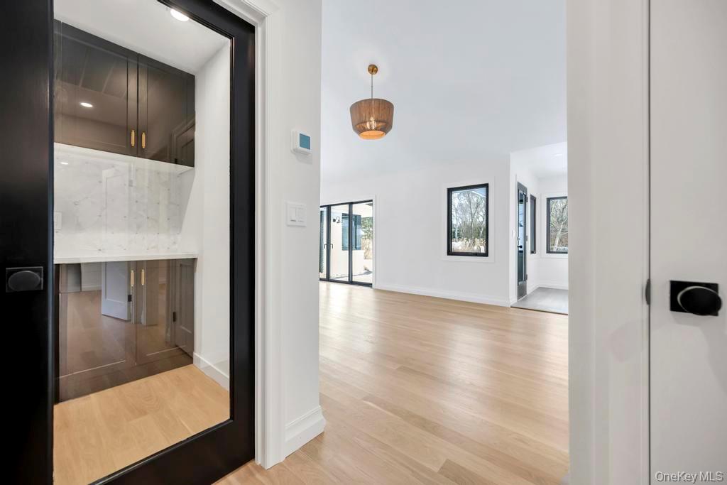 10 Lenape Road Southampton, NY 11968 - Photo 19 of 37 a view of a hallway with wooden floor and a living room