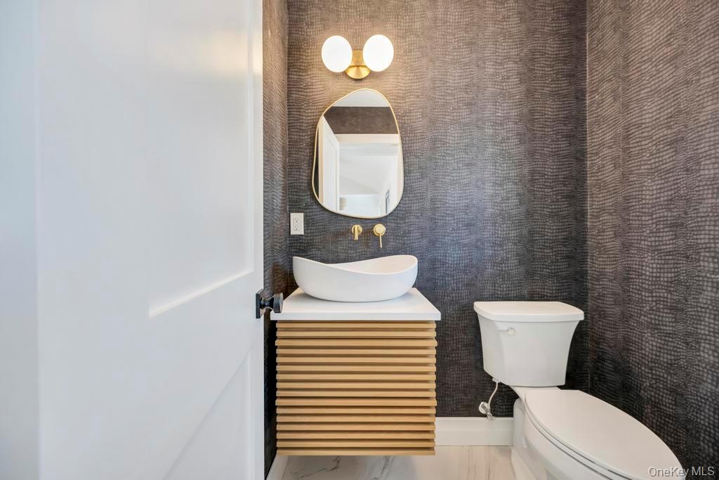 10 Lenape Road Southampton, NY 11968 - Photo 21 of 37 a bathroom with a toilet a sink and mirror
