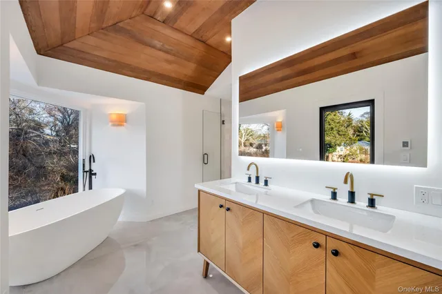 a white bath tub sitting in a bathroom next to a window