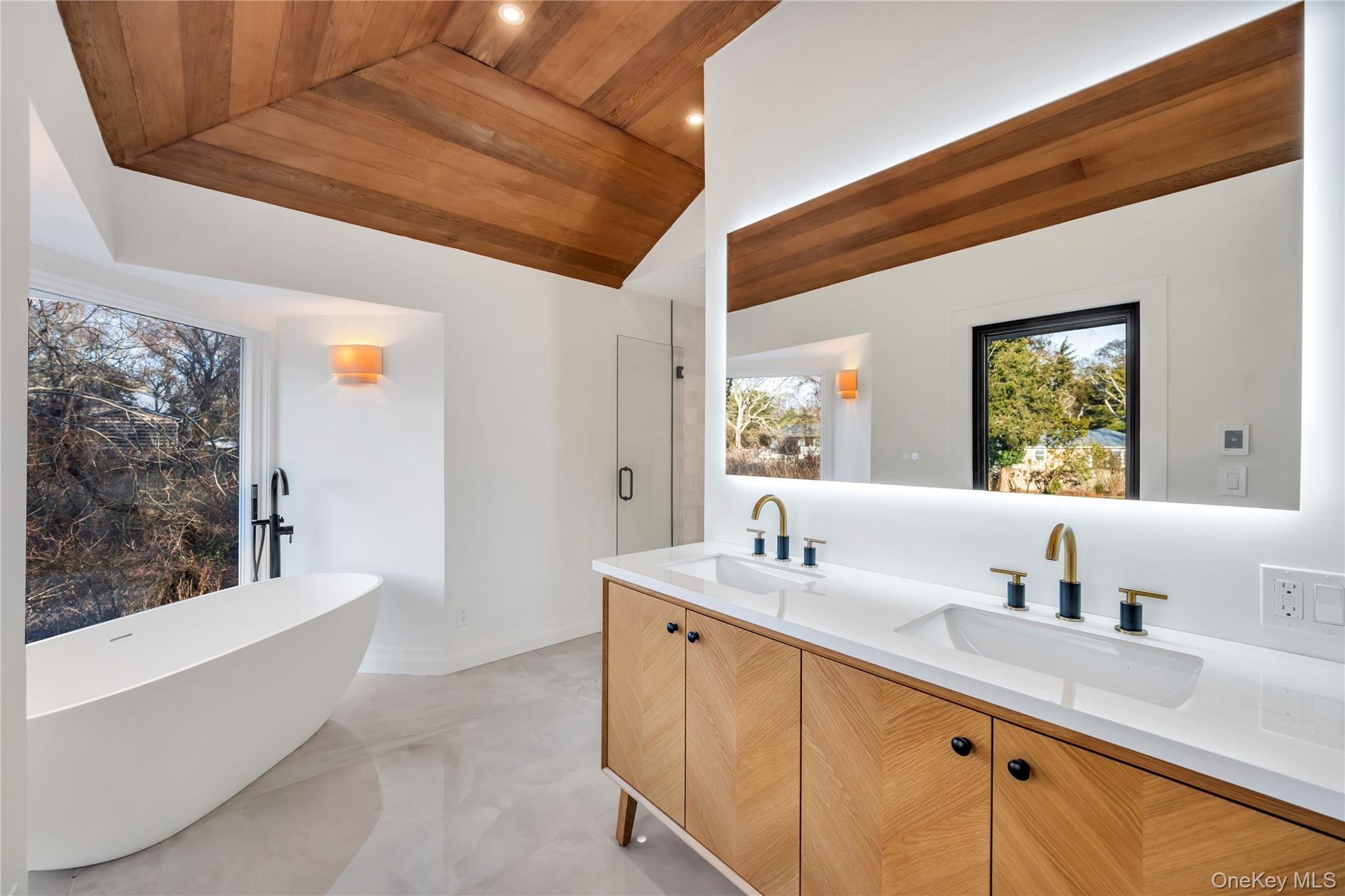 10 Lenape Road Southampton, NY 11968 - Photo 23 of 37 a bathroom with a double vanity sink a mirror and a bathtub