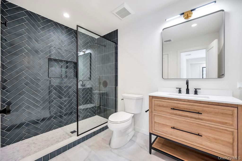 10 Lenape Road Southampton, NY 11968 - Photo 30 of 37 a bathroom with a sink a toilet and shower